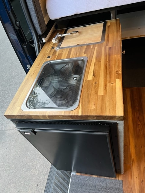  and a large side window.|Rv rental's converted van interior — photo 11
