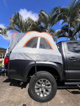 Dark grey truck with KARMATER truck bed tent under palm trees, an alternative to an RV rental for outdoor camping.