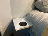 RV rental bedroom detail: a built-in shelf with a Yootech charger next to cozy gray bedding.