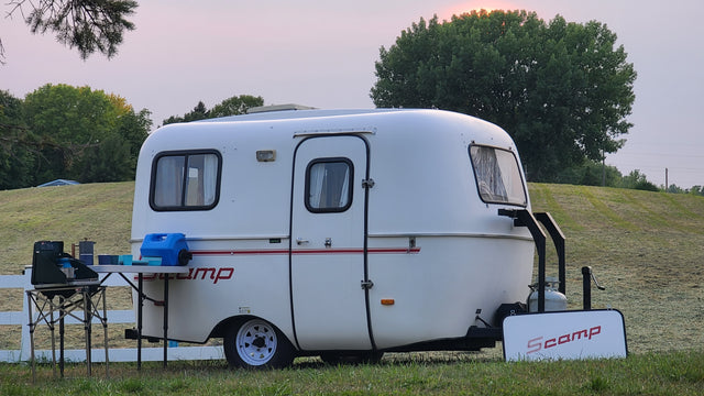 Scamp trailer ready for your next rv rental adventure, with outdoor cooking setup at sunset.