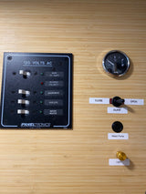 RV rental: Close-up of interior controls including 120V AC panel, fuel gauge, water pump, and dump valve on wood.