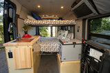 RV rental interior: compact kitchenette, upper & lower beds, and fridge, perfect for comfortable camper van trips.