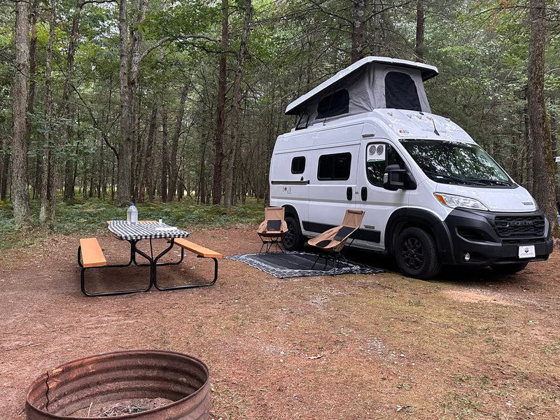  and hillside houses under a cloudy sky.|"Solis Pocket" RV rental camper van parked on a scenic road with red rock mountains under a cloudy sky — photo 7