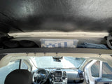 RV rental interior view: overhead storage with bin and blankets, and the vehicle's front dashboard and steering wheel.