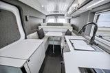 Explore a sleek rv rental camper van interior. White counters, gray walls, bed, kitchen, and dining for your adventures.