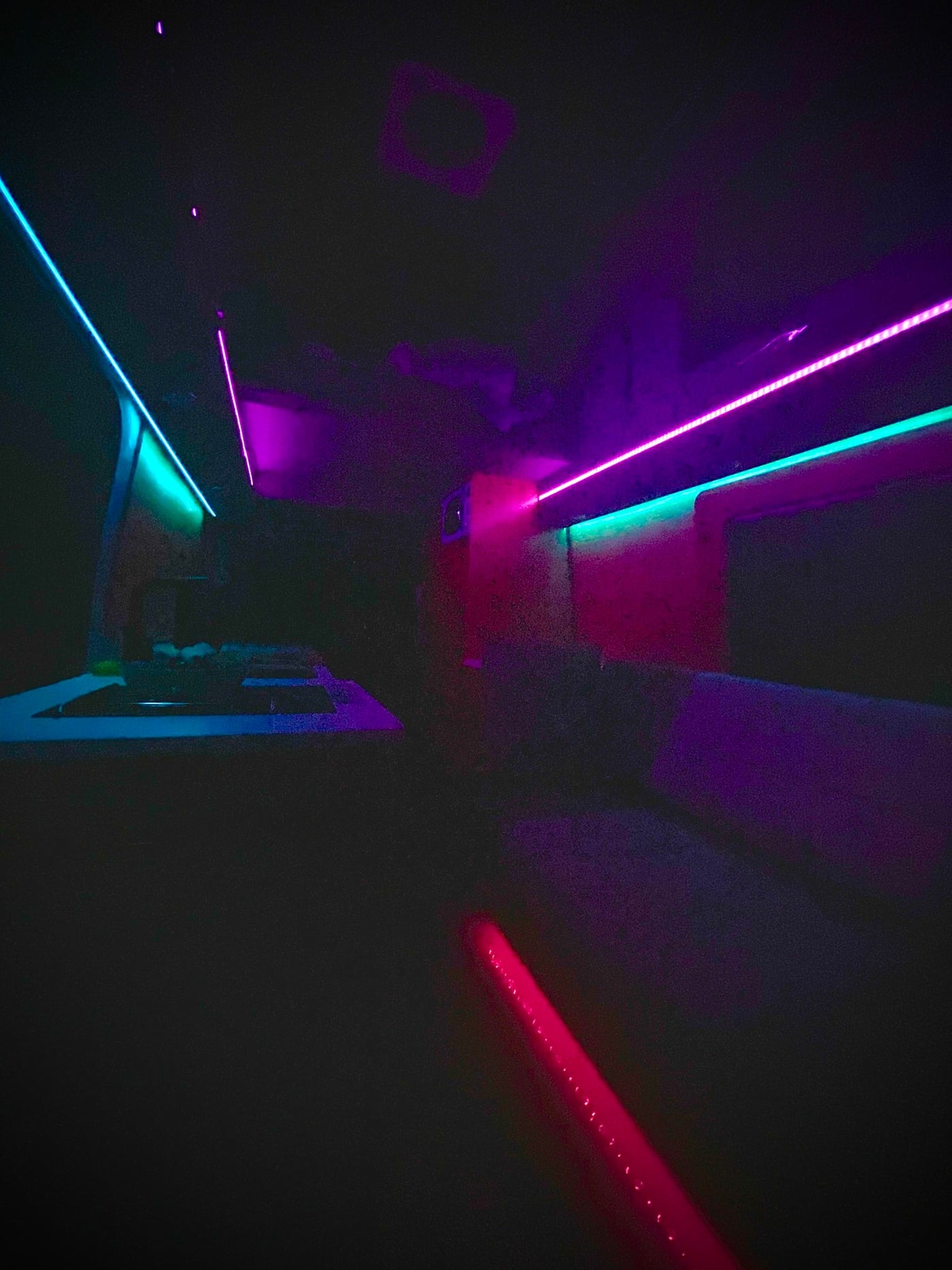 Customized RV rental interior with vibrant blue, pink, and red LED strip lights, creating a modern, lounge-like atmosphere. — photo 10