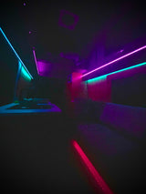 Customized RV rental interior with vibrant blue, pink, and red LED strip lights, creating a modern, lounge-like atmosphere.