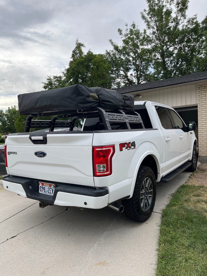 White Ford F-150 truck equipped with an RCI bed rack and black rooftop tent, offering a unique RV rental experience. — photo 10