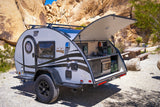 RV rental: Teardrop camper with open rear kitchen, set against desert rocks, perfect for outdoor adventure.