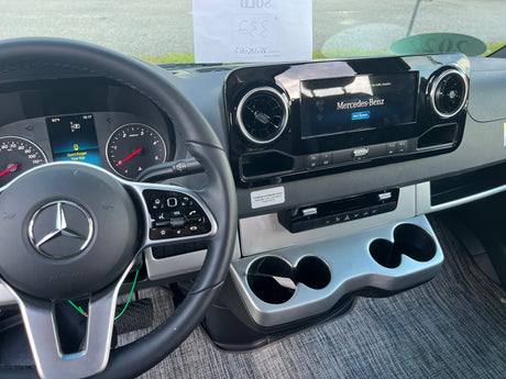 Inside a Mercedes-Benz RV rental, showing the dashboard with steering wheel, instrument cluster, and central infotainment screen.