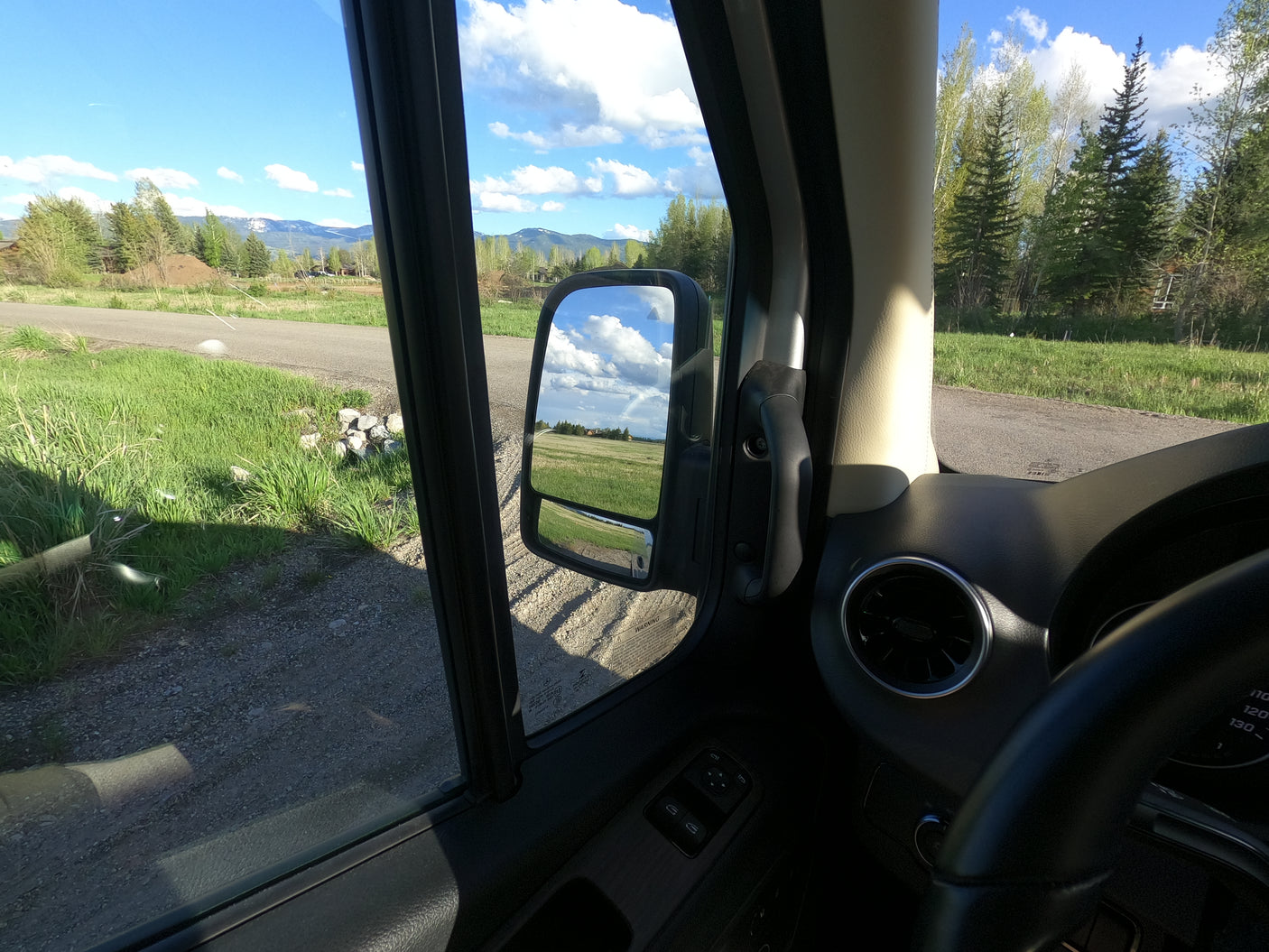 Enjoying a scenic rv rental road trip with mountain views and a clear sky from inside the camper van.