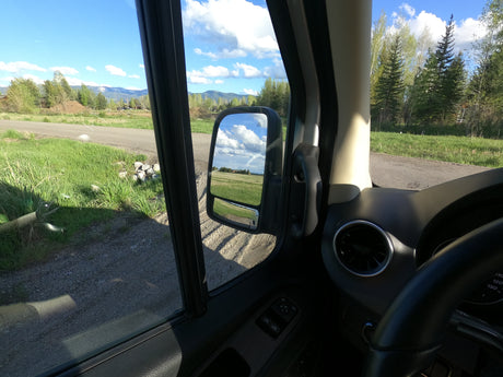 Enjoying a scenic rv rental road trip with mountain views and a clear sky from inside the camper van.
