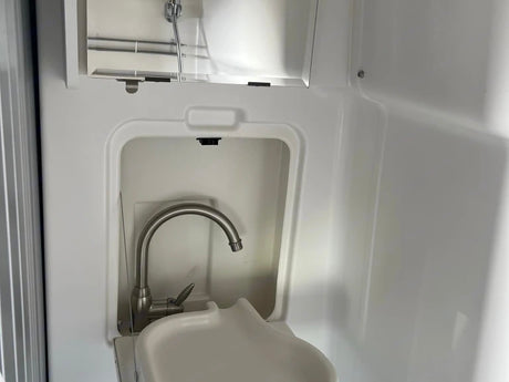 RV rental's compact wet bath features an integrated sink, faucet, and overhead shower.