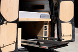 RV rental interior: Custom van conversion with a comfy bed, utility panels, and a BEDSLIDE for easy access.