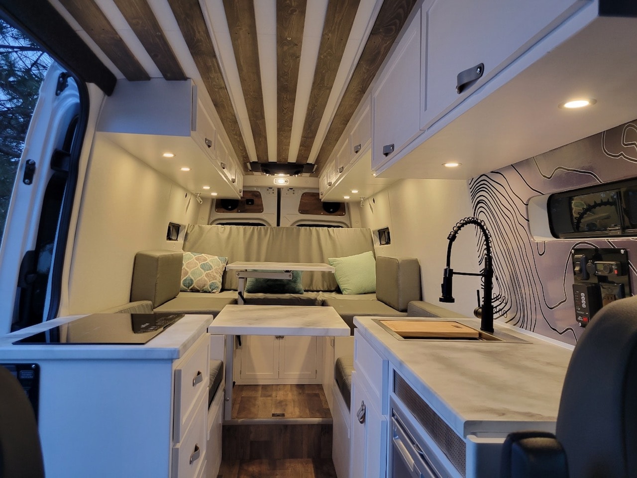 Modern RV rental interior with full kitchen, comfortable living area, and stylish wood-slat ceiling. — photo 2