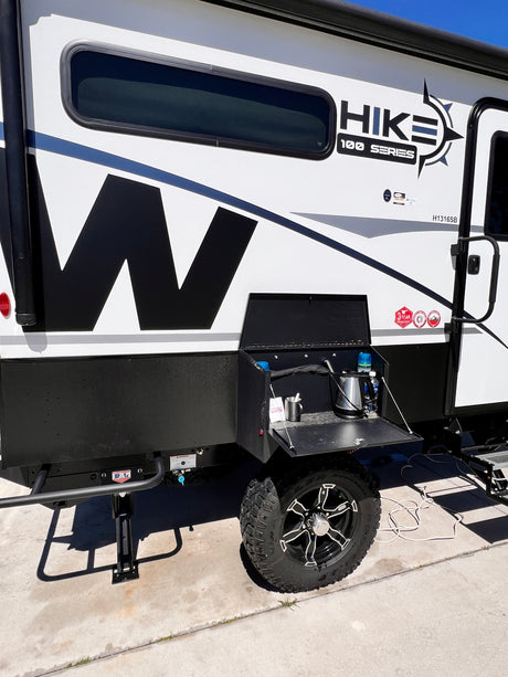 This Hike 100 Series rv rental is a rugged travel trailer, featuring an exterior kitchen setup and off-road tires.