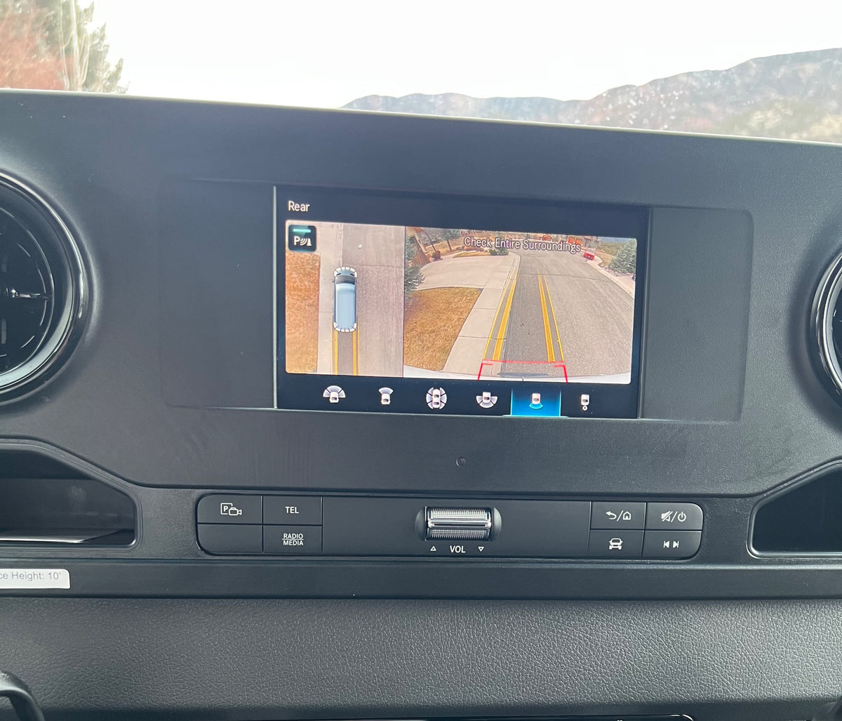 RV rental dashboard: Infotainment screen shows a backup camera view, aiding safe parking of the 10' tall vehicle. — photo 5