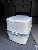 White Porta Potti 365 portable toilet (Pee Pee Only sticker) in an RV rental, ready for travel.