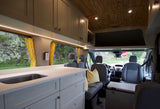 Cozy RV rental interior: custom camper van with kitchen, perfect for travel & van life adventures.