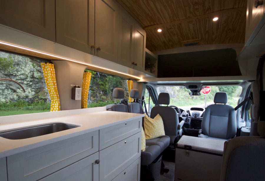  and portable fridge for your road trip.|RV rental interior features a cozy bed
