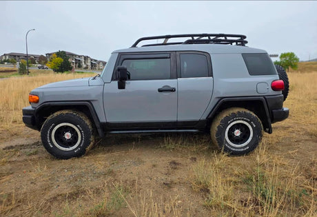 A grey Toyota FJ Cruiser, equipped with off-road tires and a roof rack, perfect for rugged adventures or an alternative rv rental.