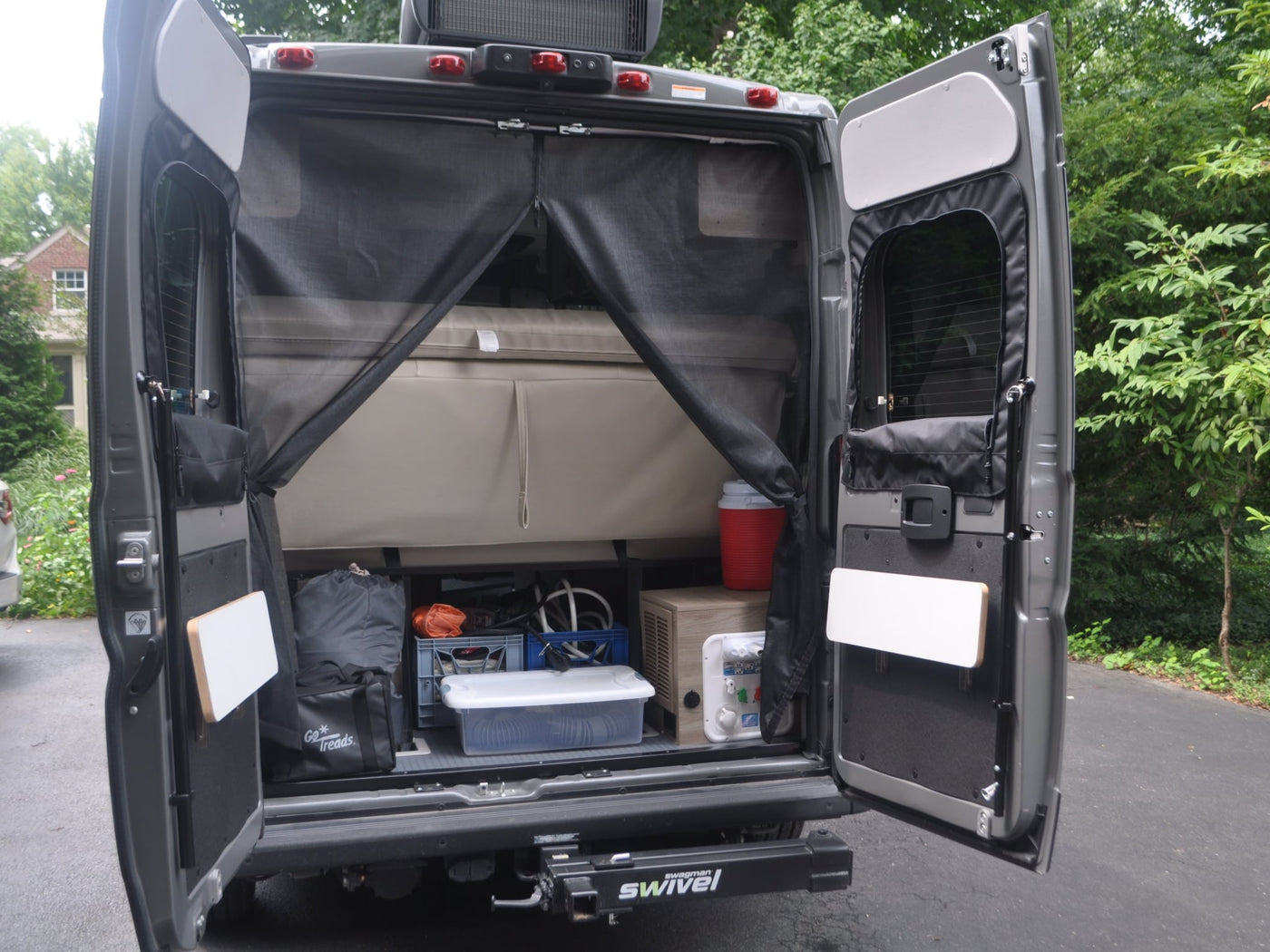  and door-mounted tables.|Comfortable RV rental bench seat with quilted beige upholstery and visible seatbelt buckles — photo 9