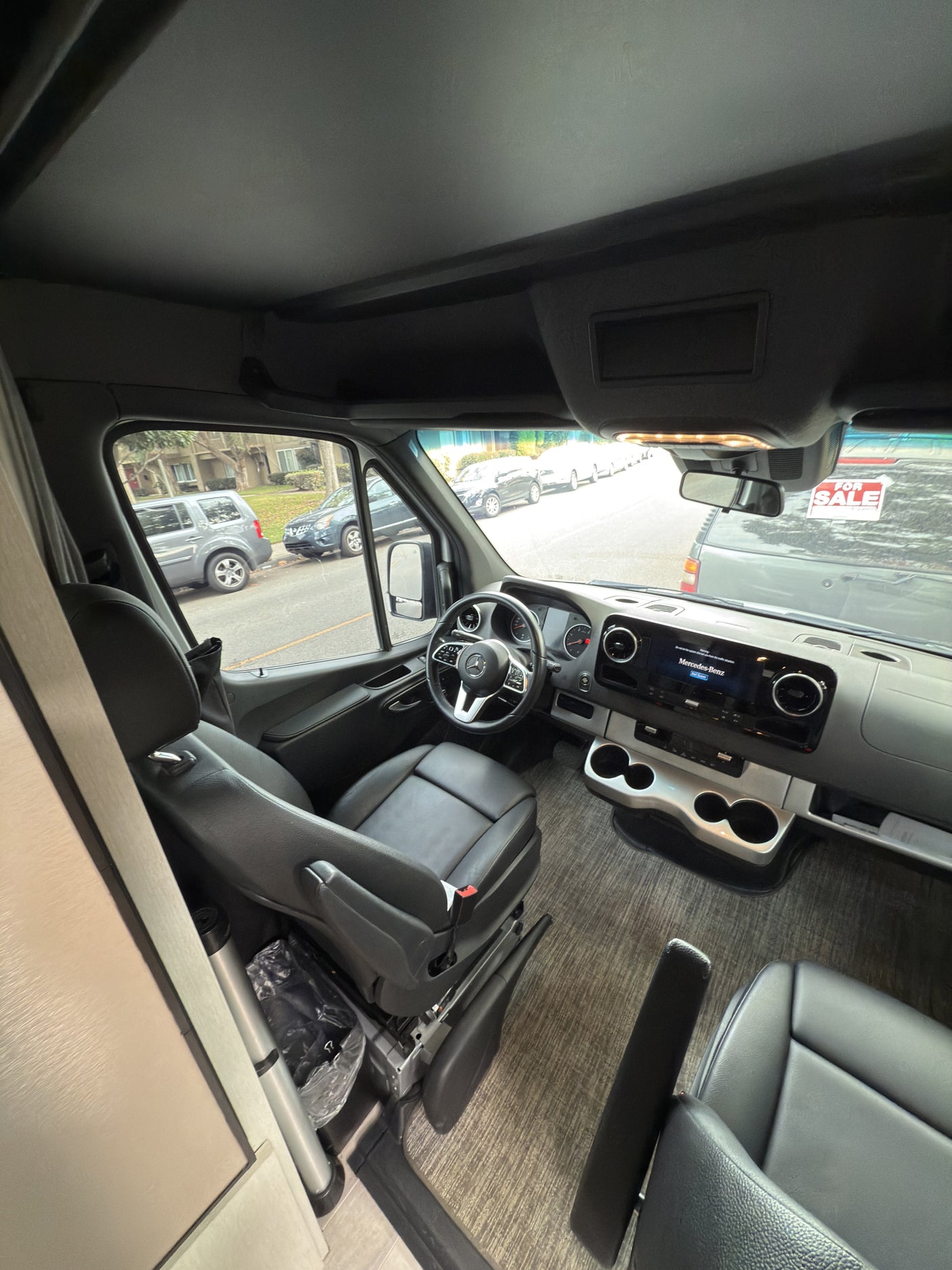 Mercedes Sprinter RV rental interior: view of the driver's area, modern dashboard, and leather seating.