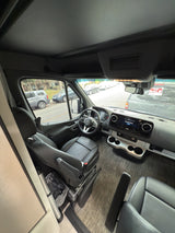 Mercedes Sprinter RV rental interior: view of the driver's area, modern dashboard, and leather seating.