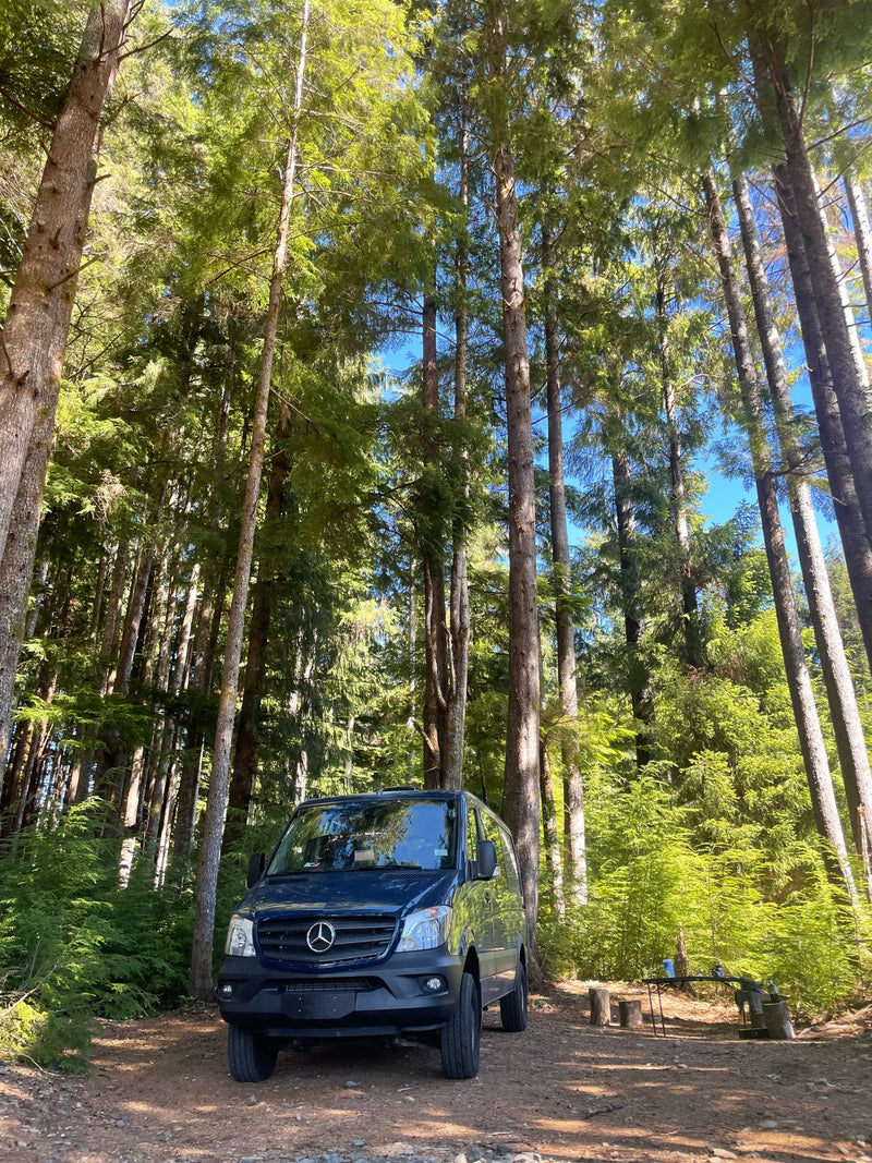  and outdoor chairs.|Cozy RV rental interior with wood finishes & brass faucet. Panoramic window offers a sunny beach view — photo 9