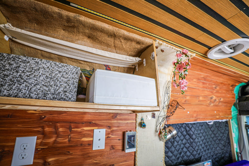 Explore this cozy RV rental interior with custom wood walls, clever storage, and decorative details. — photo 8