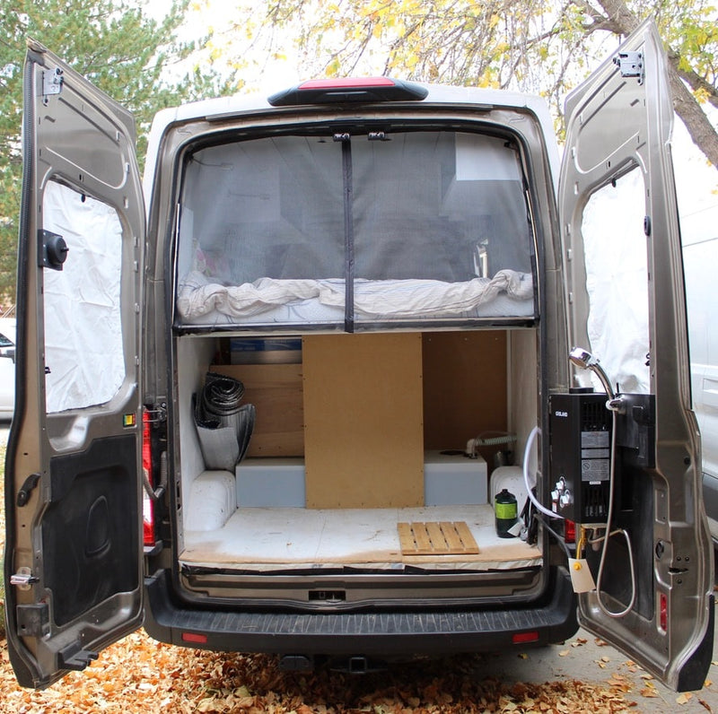  next to a raised bed.|Custom RV rental interior: teal kitchen — photo 15