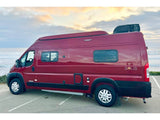 This red Winnebago Solis RV rental is parked by the ocean, ready for scenic road trips and coastal adventures.