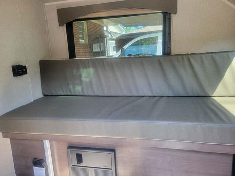 RV rental interior: Cushioned dinette, window view, USB charging, and electrical panel below.