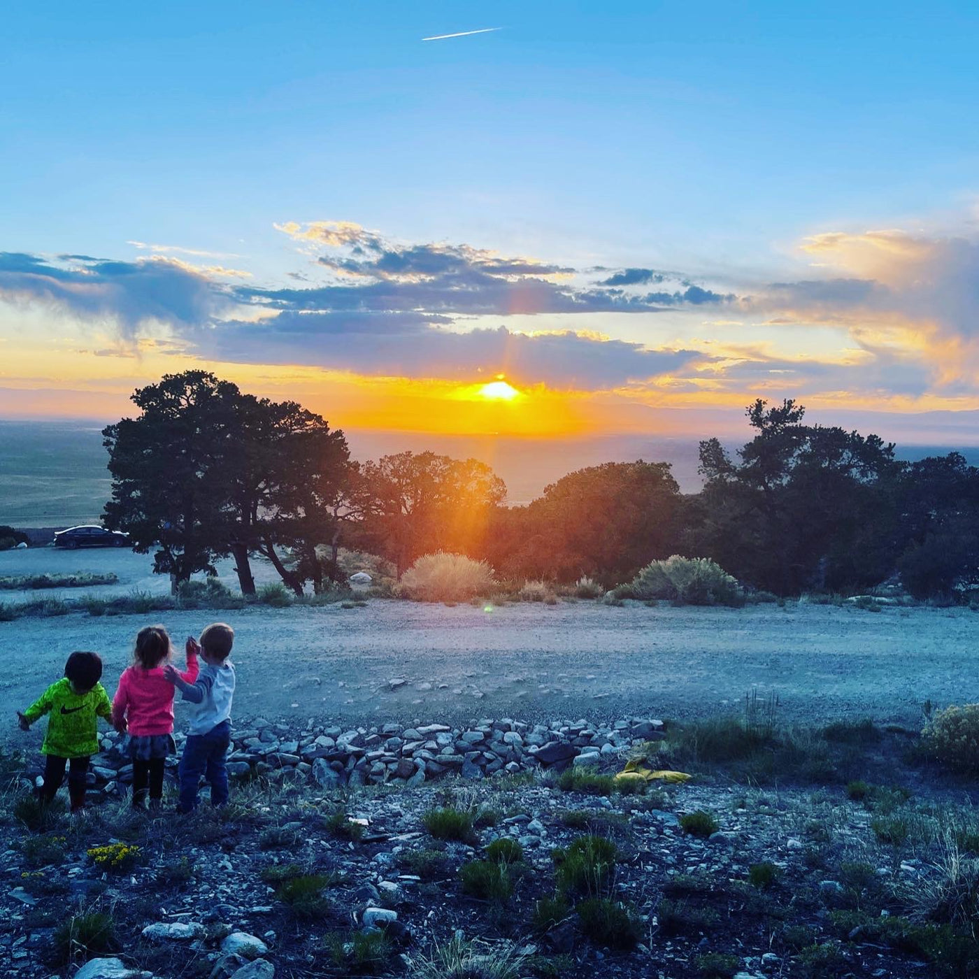 Three kids gaze at a stunning sunset over a vast landscape. An RV rental adventure offers breathtaking views like this! — photo 9