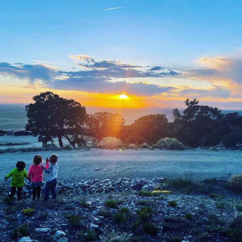 Three kids gaze at a stunning sunset over a vast landscape. An RV rental adventure offers breathtaking views like this! — photo 9