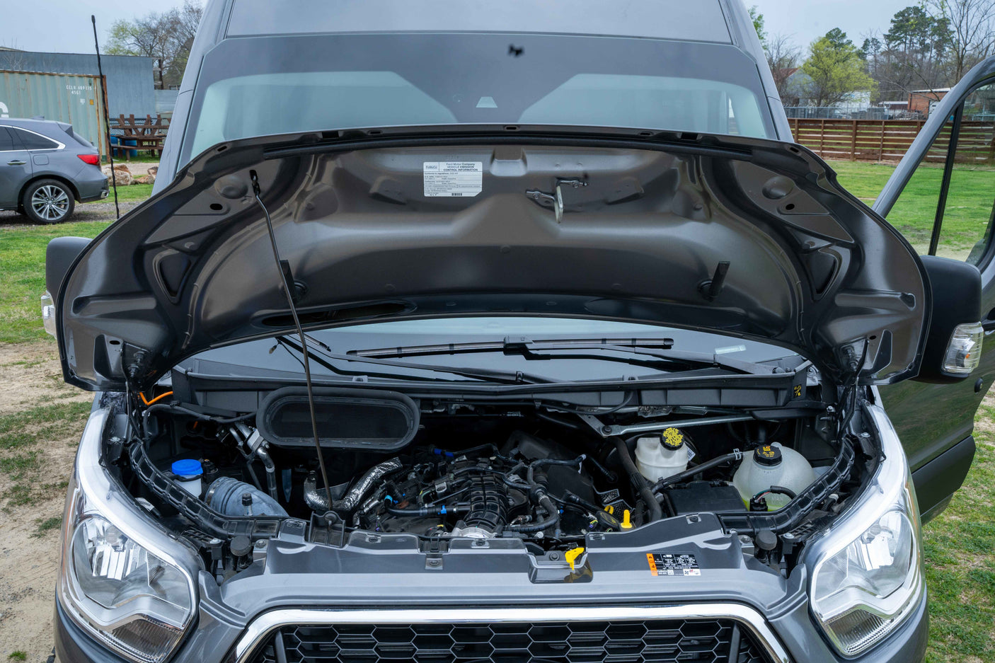 RV rental van with its hood open, revealing the engine compartment and mechanical components.