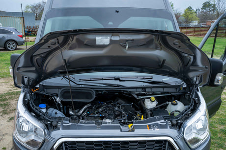 RV rental van with its hood open, revealing the engine compartment and mechanical components.
