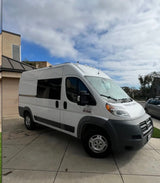 White Ram ProMaster van, an RV rental, on a paved driveway. Perfect for travel & outdoor trips.