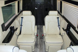 Premium rv rental interior: Two cream-colored, quilted leather captain seats with black piping, seatbelts, and side consoles.