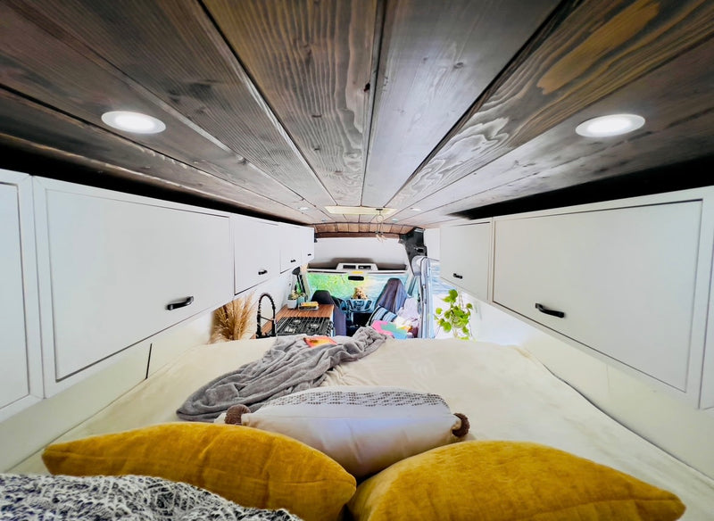 and cozy sleeping area.|Rear view of an RV rental: a white conversion van with open doors showing an elevated bed — photo 8