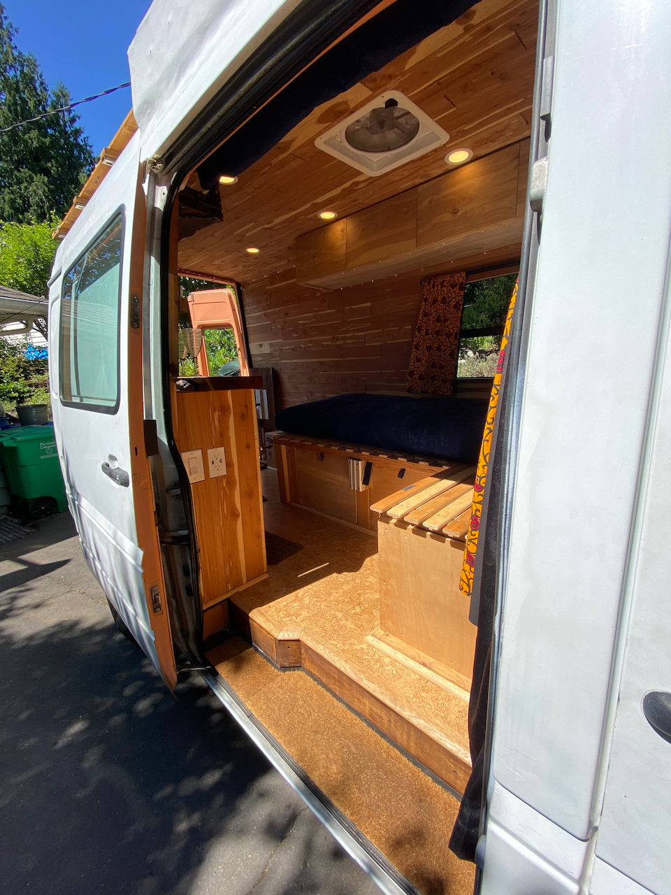 Cozy wood-paneled RV rental interior with bed, storage, and natural light, ready for adventure.