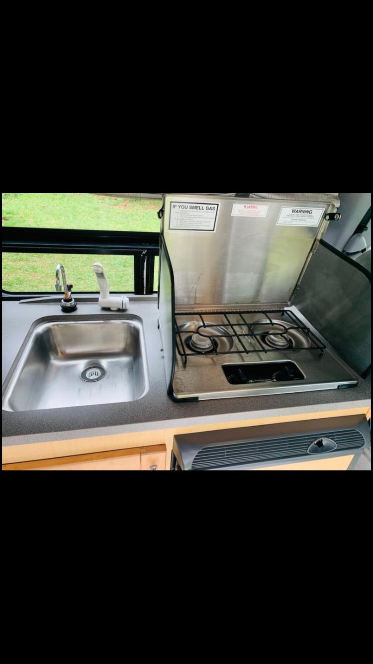 RV rental kitchenette with a stainless steel sink and two-burner gas stove, ideal for compact camping. — photo 8