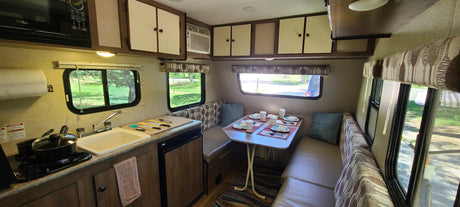 Step inside this cozy rv rental! Features a fully-equipped kitchen, dining booth, and ample storage for your travels.