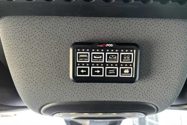 An sPOD auxiliary switch panel for vehicle lights (bar, bumper, ditch) and compressor, commonly found in an RV rental.