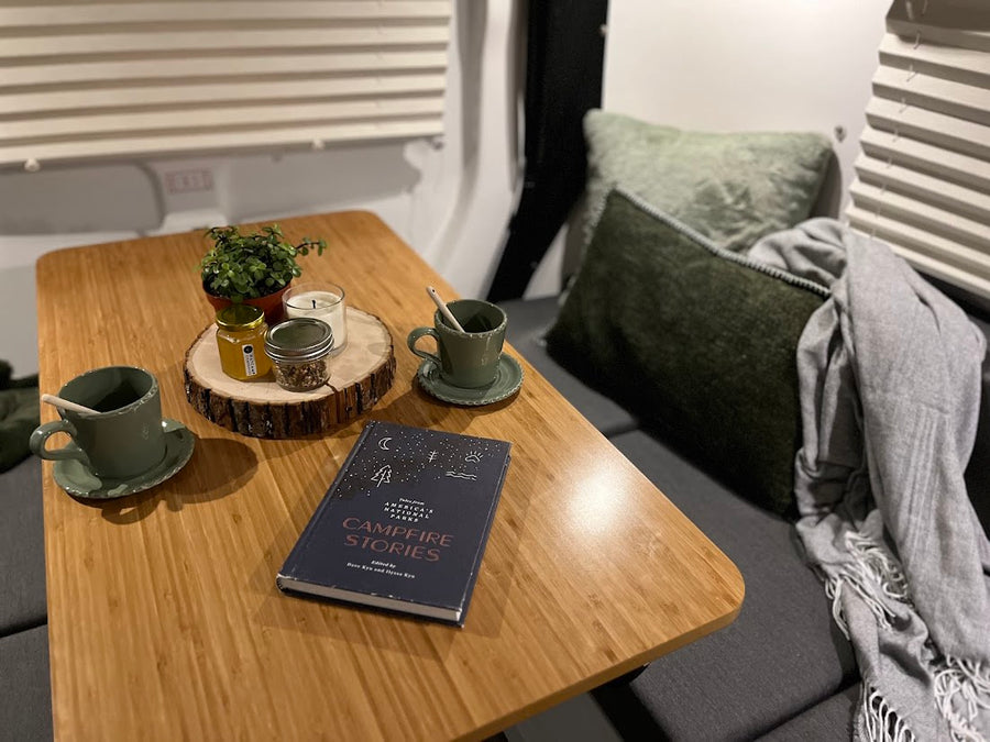  and fresh flowers on a side table.|Inviting rv rental interior showing a cozy dining area with comfy benches
