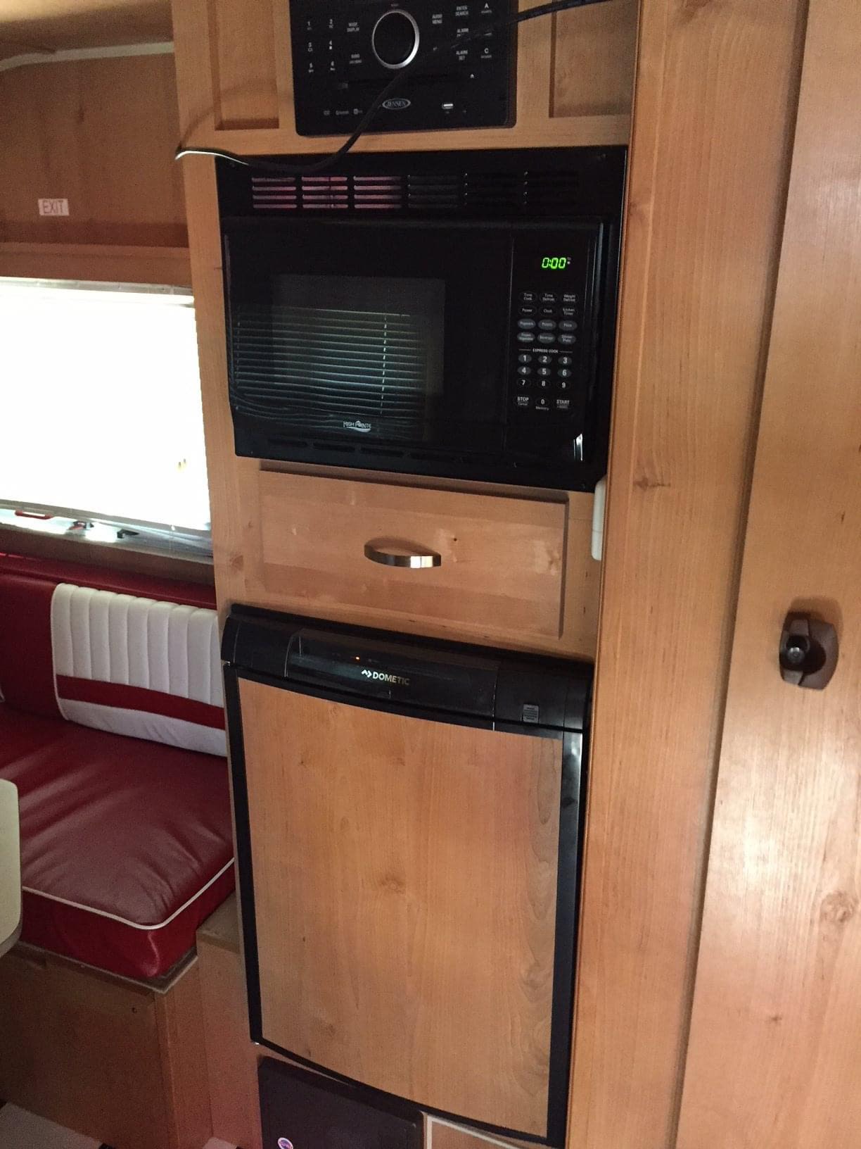  is perfectly set up for outdoor camping with a red umbrella and chairs.|Compact rv rental kitchen with sink — photo 3
