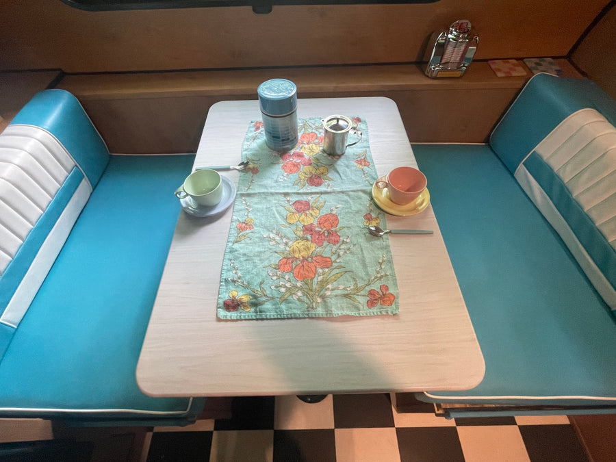  and drinks. Perfect for your next trip!|Cozy RV rental interior with a person relaxing at the dinette
