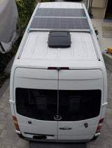 White Sprinter van, ideal for RV rental, with two roof solar panels & vent. Ready for camper adventures.