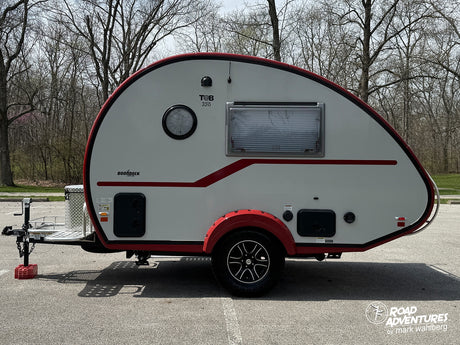 This white T@B 320 Boondock teardrop camper, featuring red trim and fender, is ready for your next rv rental trip.