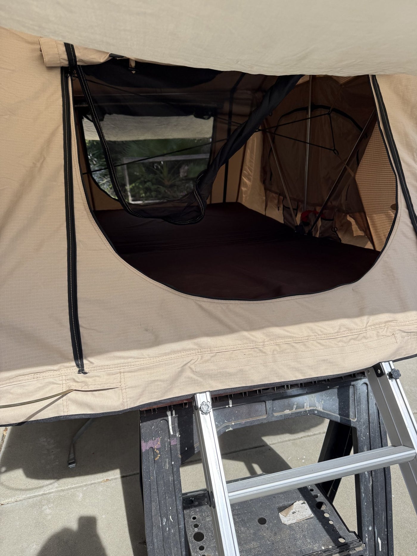 Close view of the tent door and window opening with the aluminum base rails and mounting hardware visible underneath — photo 7